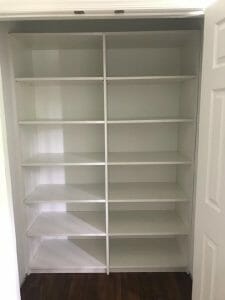 White reach-in closet featuring adjustable open shelving for folded clothes, shoes, and accessories