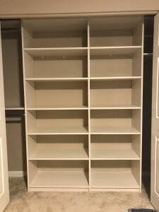 Built-in closet with open adjustable shelving and ample space for folded clothes and accessories